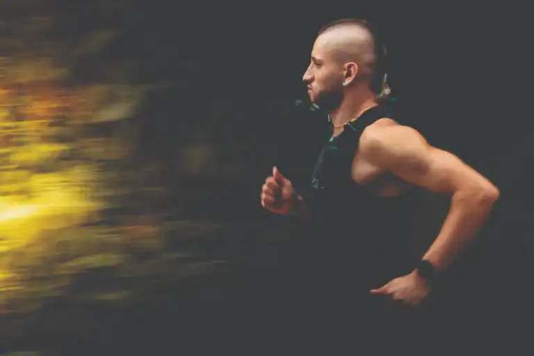 Corredor Masculino en Movimiento, Deportista en Carrera, Evento Deportivo, Fondo Oscuro, Enfoque en Futuro, Fitness y Salud, Actividad Física, Motivación Deportiva, Entrenamiento y Bienestar.