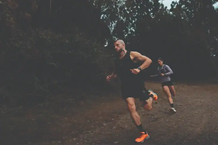 Corredores en carrera por sendero de tierra en medio de naturaleza durante evento de trail running en Colombia.