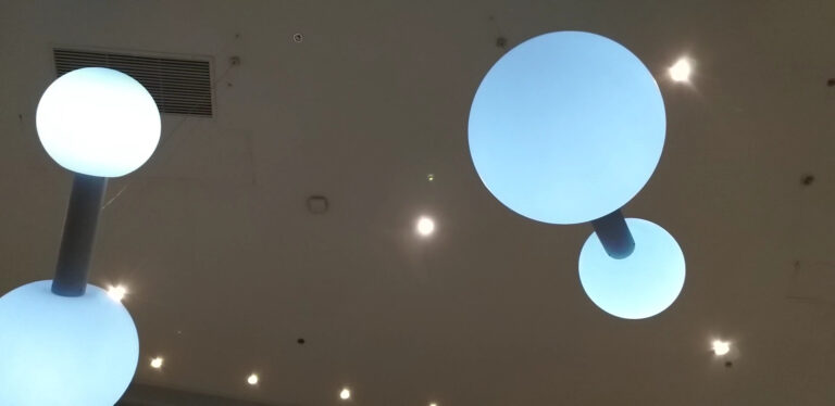 Lámparas modernas de techo iluminan un espacio interior, ideales para eventos corporativos y reuniones empresariales. Diseño minimalista y eficiente para ambientes elegantes y funcionales.