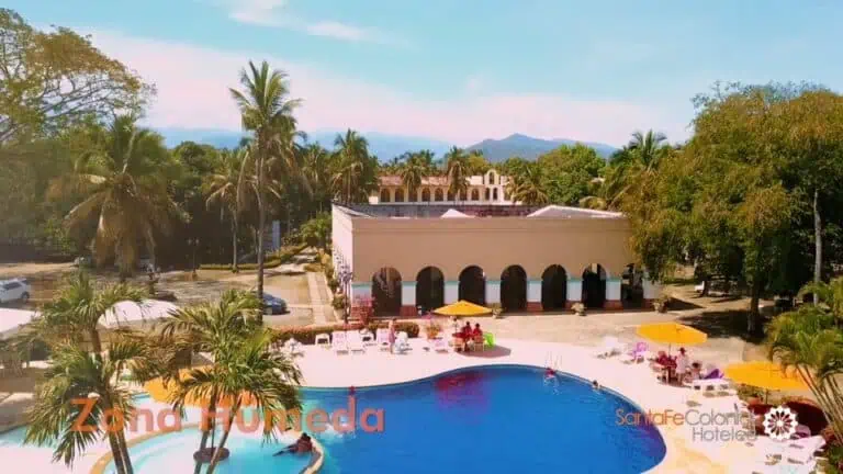 Alt: Hotel Santa Fe Colonia in Tijuana with a pool, green areas, and palm trees, ideal for events and vacations in a tropical setting.