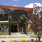 A modern outdoor event building surrounded by nature, ideal for conferences and business meetings in Colombia. It boasts innovative architectural design and spacious green spaces.