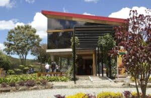 Edificio moderno para eventos al aire libre rodeado de naturaleza, ideal para conferencias y reuniones empresariales en Colombia. Diseño arquitectónico innovador y espacios verdes amplios.