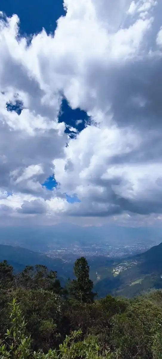 Nube y cielo sobre montañas y vegetación en un paisaje natural de Colombia.