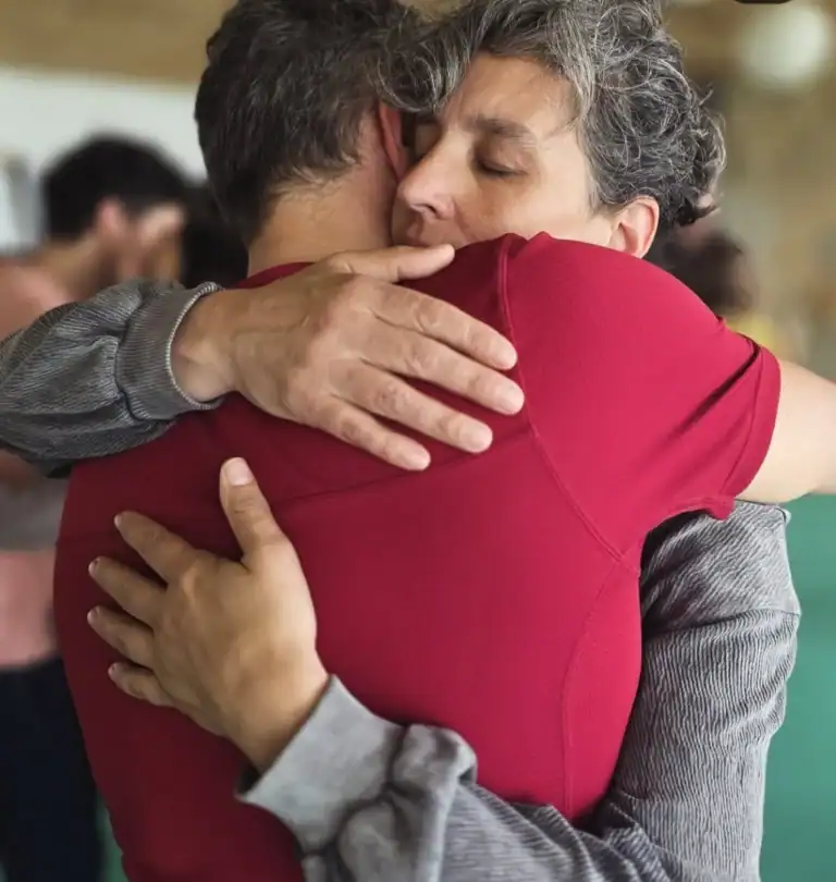 Abrazo entre dos personas en un evento, mostrando emotividad y solidaridad, ideal para contenido sobre networking, relaciones humanas y eventos sociales en Colombia.