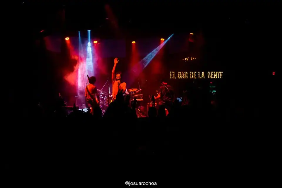 Concierto en vivo en un escenario con iluminación colorida, banda tocando música en un evento organizado por Eventario, ideal para eventos, conciertos y espectáculos en Colombia.