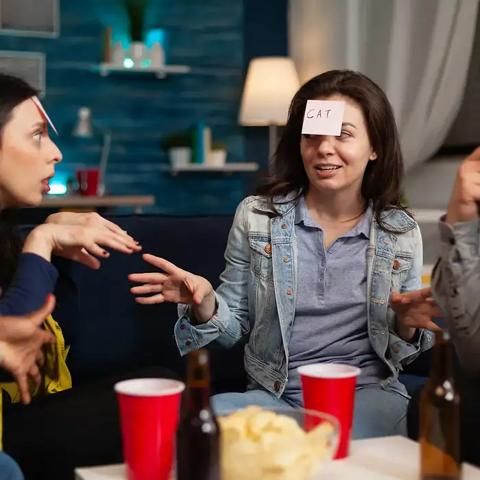 Juegos y convivencia en reunión social con amigos, utilizando notas adhesivas para actividades divertidas y desafíos en un ambiente casual y acogedor.