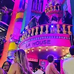 Vibrante ambiente en un evento en La House, con iluminación de colores y personas socializando, ideal para promover eventos y experiencias en lugares de ocio y entretenimiento en Colombia.