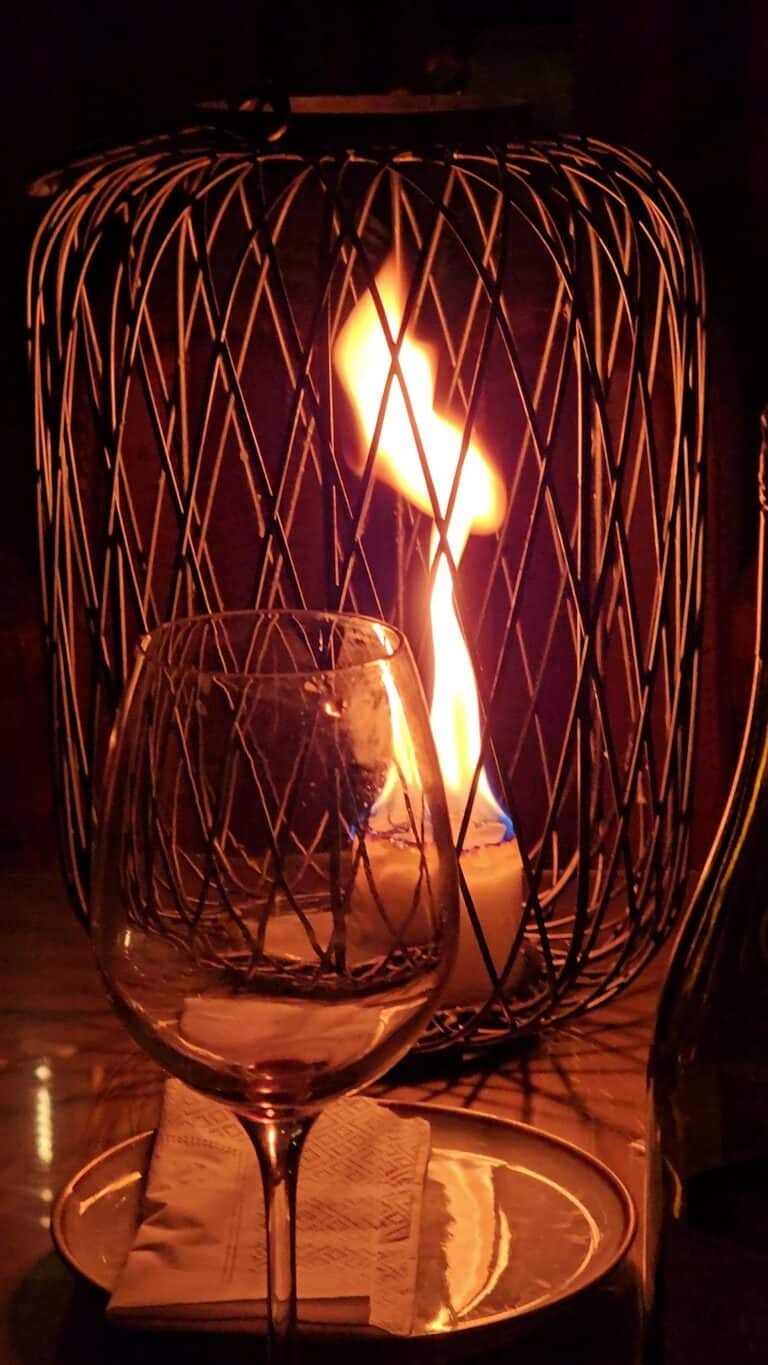 Lámpara de candelabro con vela encendida, ideal para eventos elegantes y ambientes acogedores, destacando la decoración con iluminación cálida.