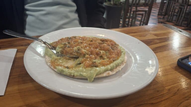 Arepa con relleno tradicional en Arepería Casa Arte, un lugar destacado en Eventario.co para disfrutar de auténtica comida venezolana en un ambiente acogedor.