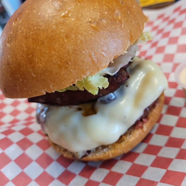 Hamburguesa en Braaap Café con queso derretido, carne jugosa, lechuga y pan suave, perfecta para los amantes de la comida rápida y deliciosa.