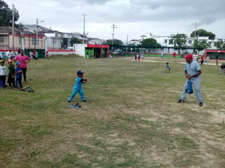 Árbitro y niños jugando en campo deportivo Blas De Lezo, un lugar ideal para actividades recreativas y deportivas en la comunidad.