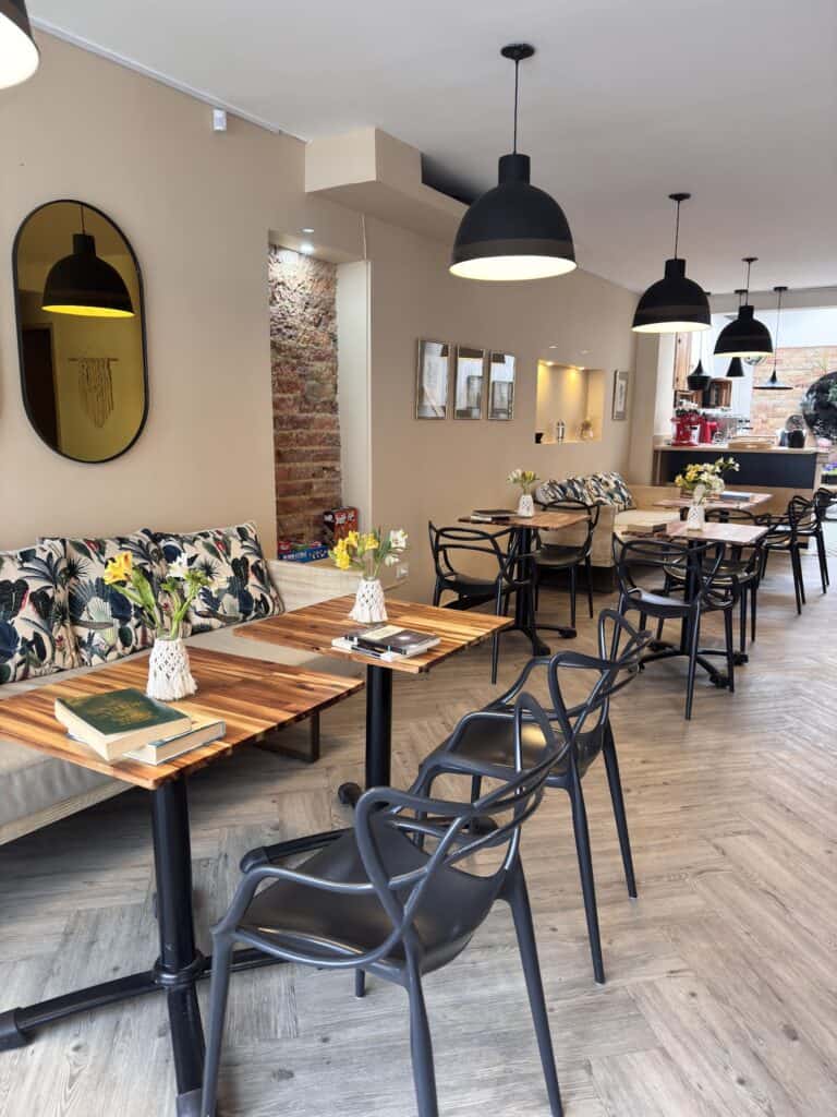 Espacio de estar moderno y acogedor con mobiliario elegante y decoración floral, ideal para eventos y reuniones en un ambiente cómodo y bien iluminado.