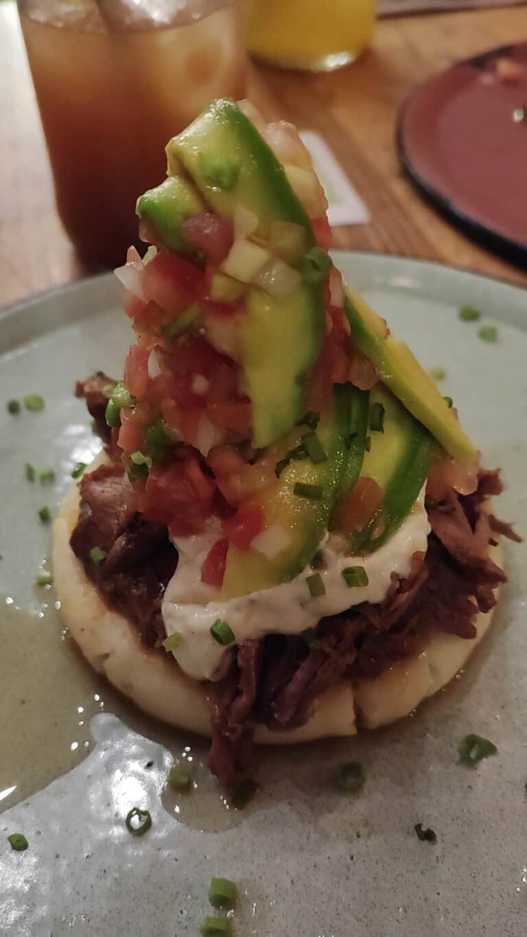 Tacos de carne con aguacate, cebolla y cilantro en Lulo Café Bar, un lugar ideal para disfrutar de comida deliciosa y ambiente acogedor en un entorno urbano.