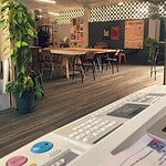 Espacio interior en La Bruja Riso con mesas, sillas y decoración moderna para eventos culturales y sociales.