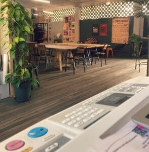 Espacio interior en La Bruja Riso con mesas, sillas y decoración moderna para eventos culturales y sociales.