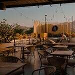 Terraza del Viajero Santa Marta con vista panorámica y ambiente relajado. Disfruta de bebidas y buena compañía en un espacio al aire libre con vistas a las montañas.