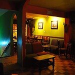 Ambiente del Yagé Bar con iluminación cálida y decoración vibrante, ideal para disfrutar de bebidas tradicionales y experiencias culturales en un espacio íntimo y relajante.