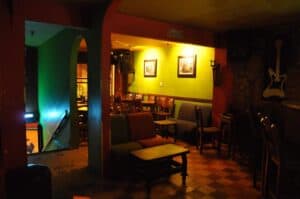 Ambiente del Yagé Bar con iluminación cálida y decoración vibrante, ideal para disfrutar de bebidas tradicionales y experiencias culturales en un espacio íntimo y relajante.