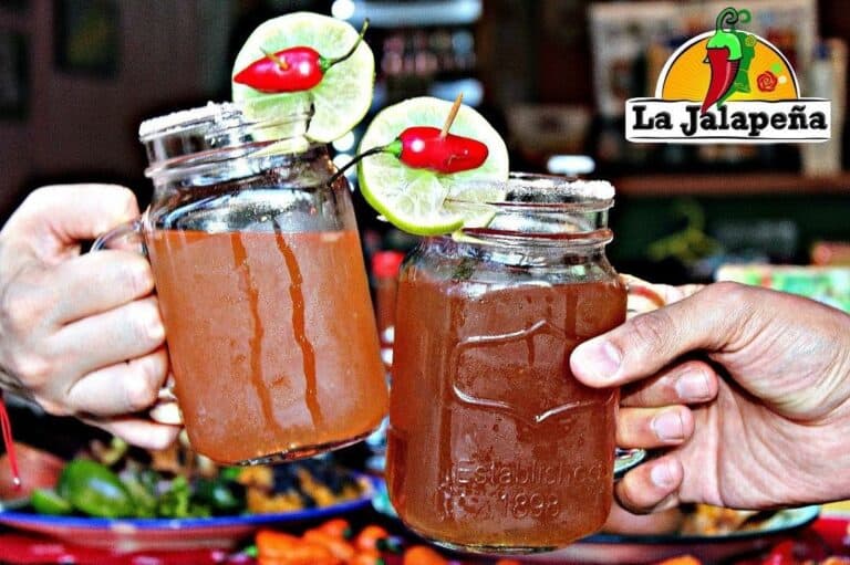 Refrescos en frascos con rodajas de limón y cerezas, en un ambiente de restaurante.