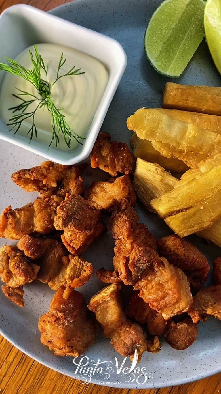 Plato de pescado frito con papas y salsa verde en Punta Las Velas, restaurante en Club de Playa, ideal para disfrutar de comida marina en un ambiente relajado.