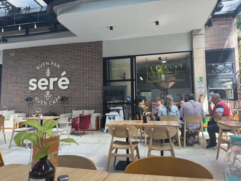 Agradable ambiente en Seré, cafetería campestre con clientes disfrutando de bebidas y comida al aire libre.