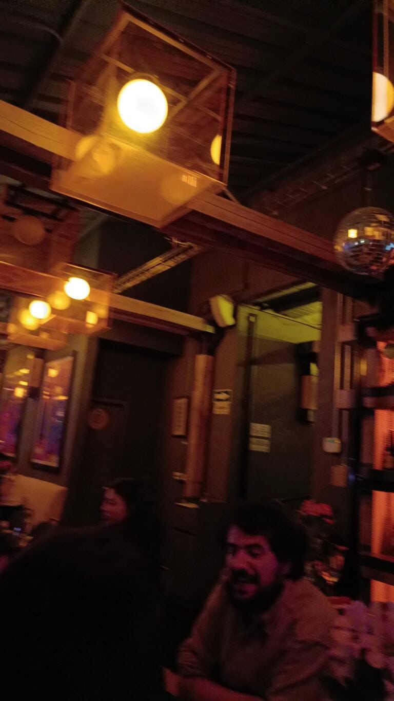 Imagen que muestra un ambiente acogedor en Listening Wine Bar con iluminación cálida y decoración moderna.