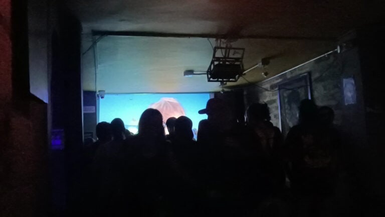 Personas disfrutando en un Yagé Bar, un espacio de bienestar y cultura, con ambiente oscuro y luces suaves, en un evento organizado por Eventario.