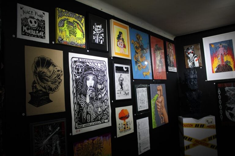 Obras de arte en exhibición en Eventario, relacionadas con el tema "El Infierno", mostrando estilos diversos y expresivos en una galería moderna.