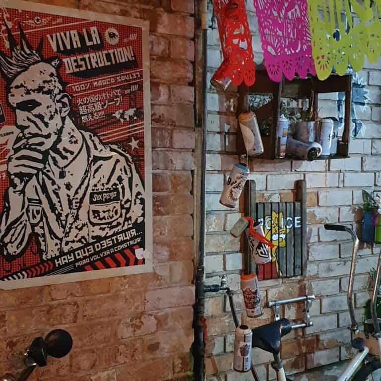 Imagen de graffiti y decoraciones en un espacio urbano llamado El Infierno, con paredes de ladrillo y arte callejero que refleja un ambiente alternativo y artístico.