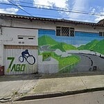 Mural en una calle de Bogotá que representa un paisaje natural con montañas y un ciclista, promoviendo el ciclismo y la vida saludable en la ciudad.
