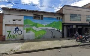 Mural en una calle de Bogotá que representa un paisaje natural con montañas y un ciclista, promoviendo el ciclismo y la vida saludable en la ciudad.
