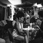 Personas en un evento privado para miembros, compartiendo en un espacio sofisticado con decoración moderna y ambiente íntimo.