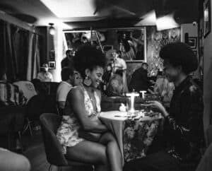 Personas en un evento privado para miembros, compartiendo en un espacio sofisticado con decoración moderna y ambiente íntimo.