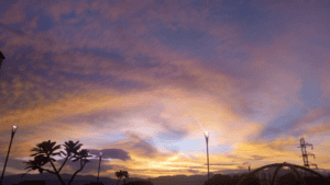 Una vista impresionante del atardecer en UVA de la Armonía, con un cielo colorido y nubes doradas, ideal para eventos y actividades al aire libre en un entorno natural y armonioso.