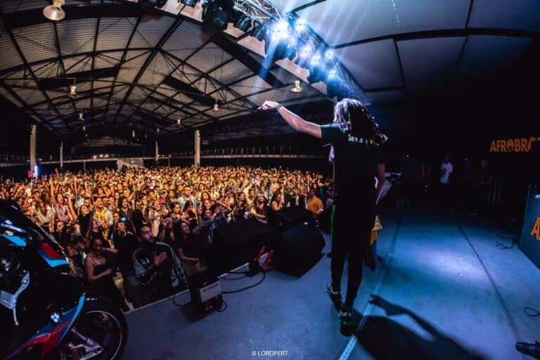 Espectáculo en vivo en el Centro de Eventos y Exposiciones, con una gran audiencia disfrutando de música y entretenimiento en un ambiente vibrante y moderno.