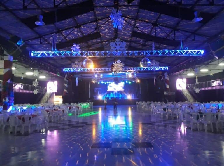 Espacio amplio y moderno en el Centro de Exposiciones y Eventos, decorado con luces y adornos navideños, ideal para eventos y celebraciones en la ciudad.