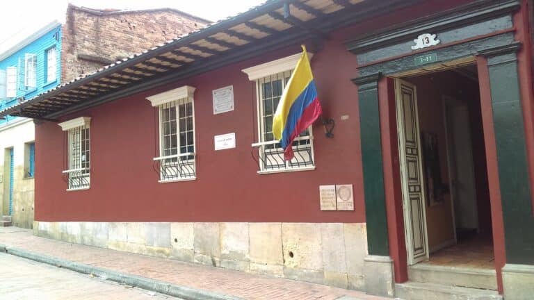 Fachada de la Casa de Poesía Silva en Bogotá, un espacio cultural dedicado a la promoción de la poesía y las artes, con bandera colombiana en la entrada.