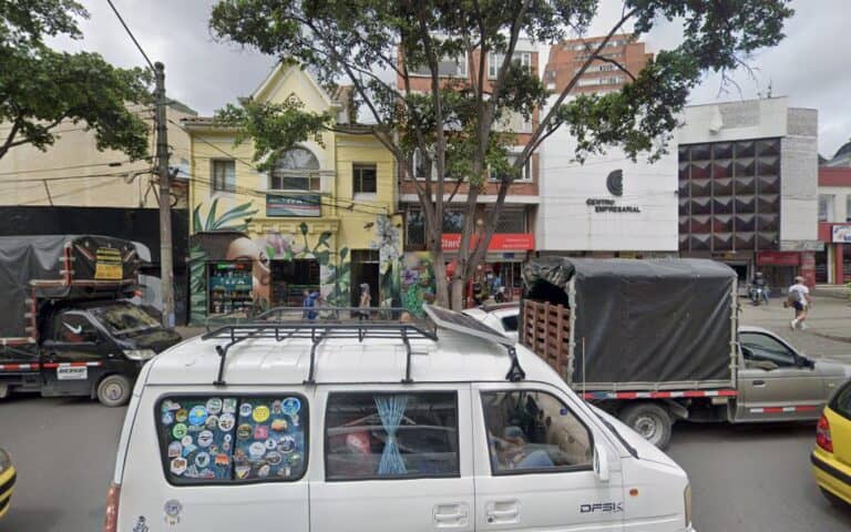Amplia vista del espacio de eventos Espacio 64 en Bogotá, con vehículos y personas participando en un evento de networking y colaboración en un entorno urbano vibrante.