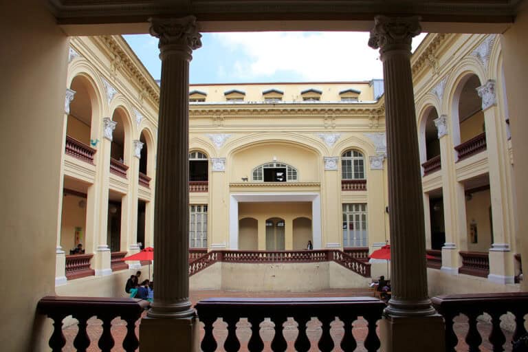 Puerta de entrada a la Facultad de Artes ASAB, mostrando su arquitectura clásica y elegante con columnas y arcos.