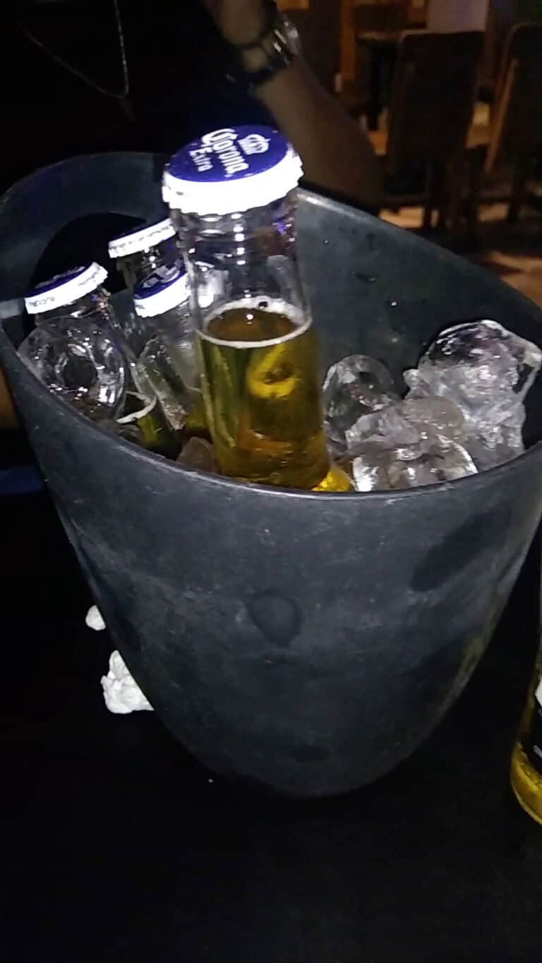 Botellas de cerveza en hielera con hielo en un evento social en Cartagena.